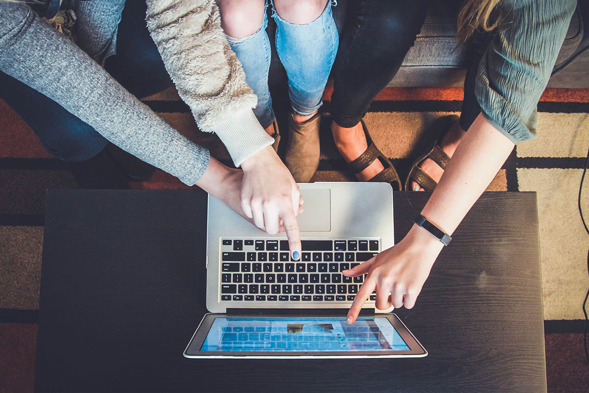 3 Girls Huddled Around A Laptop Browsing Online Forums Safely