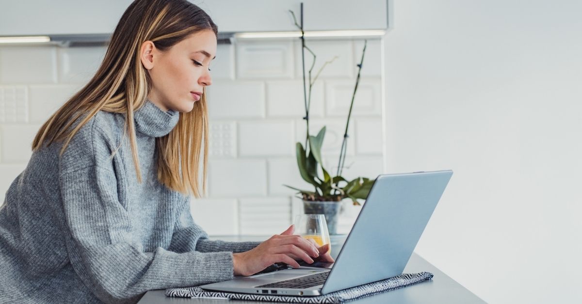 young woman sitting at table with laptop
